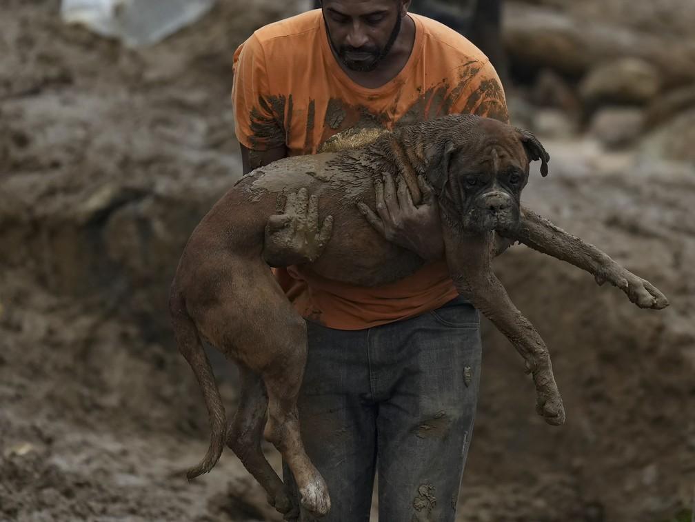 1602 - Homem resgata um cachorro de escombros aps o deslizamento no Morro da Oficina em Petrpolis RJ Foto Silvia IzquierdoAP